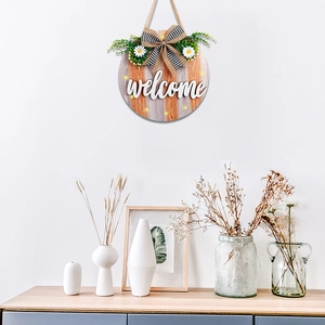 Detail of wooden welcome sign with LED lights, buffalo plaid bow, and white daisies
