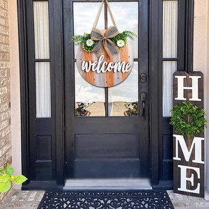 Detail of wooden welcome sign for front door with 3D letters and greenery decor