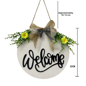 Detail view of 30cm wooden welcome sign with 3D text, faux greenery and bow decoration