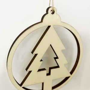 Macro view of laser-cut wooden Christmas tree ornament with layered 3D hollow design