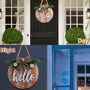 Detail of round wooden welcome sign showing day and night views with warm LED lights
