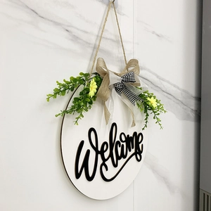 Detail of wooden welcome sign with faux greenery, yellow flowers, and burlap bow
