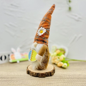 Detail van de paaskabouter met oranje geruite hoed, witte madelief en gekleurd ei