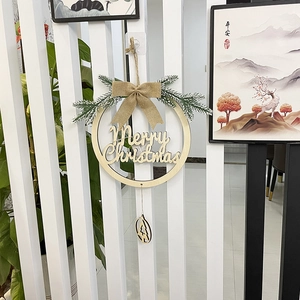 Detail of wooden Merry Christmas wreath with burlap bow and snowy pine needles