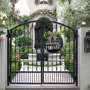 Round Easter welcome home wooden door sign with plaid bow and greenery on garden gate