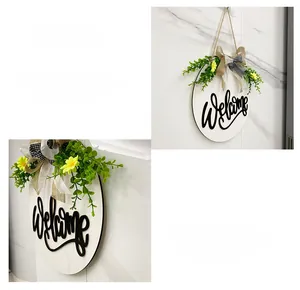 Detail of wooden welcome sign with layered burlap bow and faux greenery for door decor