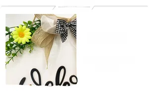 Detail of white wooden welcome sign with yellow daisies and burlap plaid bow