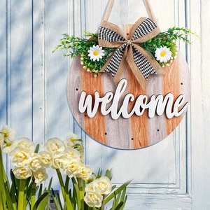 Macro detail of round wooden welcome sign with 3D white text and floral bow on blue door