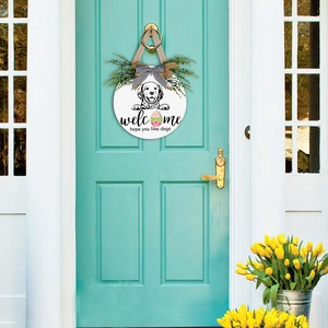 Close-up of wooden welcome sign with dog illustration and easter egg on green door