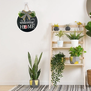 Detail of wooden welcome sign with green foliage and Easter bunny egg motif on white wall