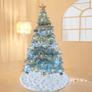 Blue artificial Christmas tree with silver ornaments and white faux fur snowflake tree skirt