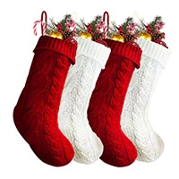 Close-up of knitted Christmas stockings with festive pine branches and candy canes