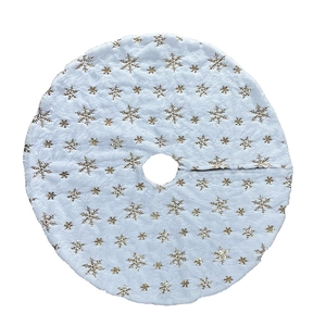 White plush Christmas tree skirt featuring golden sequin snowflakes on a clean background