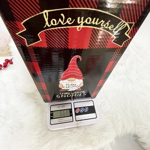 Christmas gnome gift box in red plaid pattern weighing 668g on a digital scale