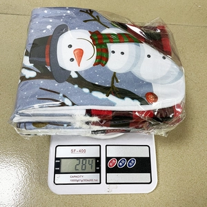 Detailed view of folded Christmas snowman stocking gift bag on scale weighing 284g