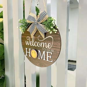 Détail de la plaque de bienvenue en bois avec nœud en toile et verdure artificielle