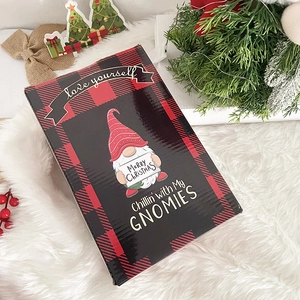 Close-up of a buffalo plaid Christmas gift box featuring a festive gnome illustration