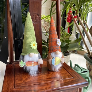 Detail van Pasen kabouters pluche met wortel en ei op traditionele houten achtergrond