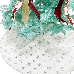 Close-up of white plush Christmas tree skirt with silver sequin snowflake patterns