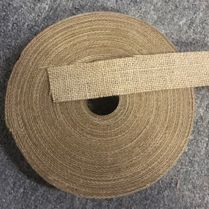 Detailed texture of natural burlap ribbon roll for Christmas tree decor and DIY crafts