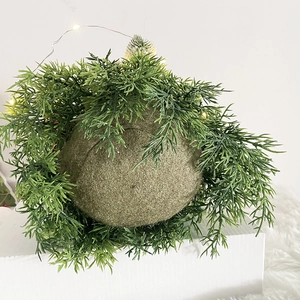 Detail of LED lit green moss ball ornament with artificial pine needles for Christmas