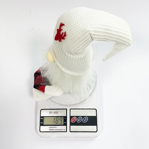 Christmas gnome plush with long white knitted hat and red antlers on a digital scale