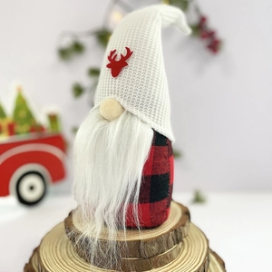 Détail d'un gnome de Noël avec bonnet blanc à renne et corps à carreaux rouges et noirs