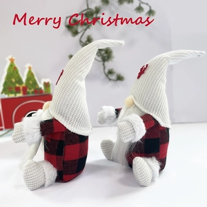 Close-up of plush Christmas gnomes with red and black plaid fabric and knit reindeer hats