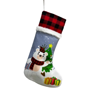 Detail of Christmas stocking with buffalo plaid cuff and polar bear holiday print