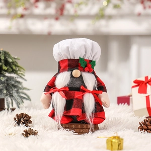 Gnomo chef natalizio con vestito a quadri rossi e neri, trecce bianche e cappello da cuoco