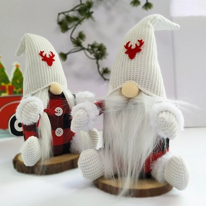 Close-up of plush Christmas gnomes with buffalo plaid coats on natural wood bases
