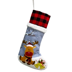 Detailed view of Christmas stocking with reindeer pattern and red buffalo plaid trim