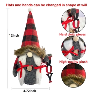 Detail of Christmas gnome plush featuring red black plaid hat and wooden JOY sign