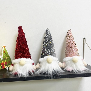 Detail von drei gesichtslosen Weihnachtswichteln mit Paillettenhüten in Rot, Grau und Rosa