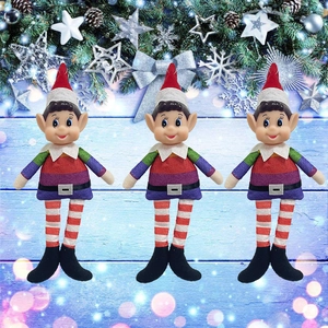 Three rainbow striped Christmas elf dolls with red hats on light blue wood background