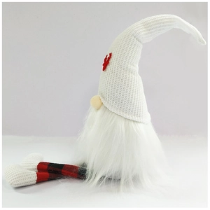 Close-up of a Christmas gnome with white knitted hat, reindeer patterns and long plaid legs