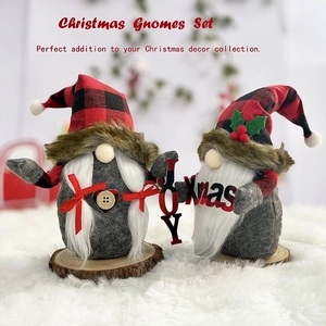 Pair of festive Christmas gnomes with plaid hats on wood bases holding JOY and Xmas signs