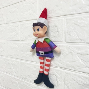 Macro detail of Christmas elf doll with rainbow shirt and red hat on white background