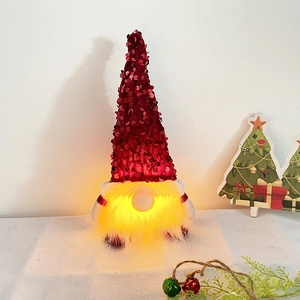 Leuchtender Weihnachtsgnom mit weinrotem Paillettenhut und warm leuchtendem LED-Bart