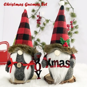 Close-up of JOY and Xmas Christmas gnomes with red and black plaid hats on wood base