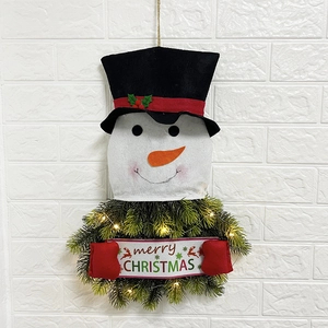 Detail of Christmas snowman wreath with warm LED lights and merry Christmas banner