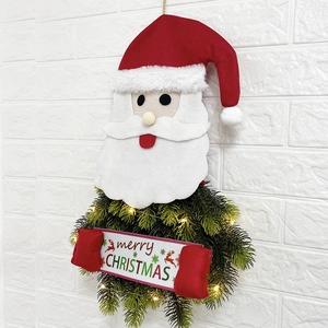 Close-up of LED lit Christmas wreath with Santa Claus and Merry Christmas sign