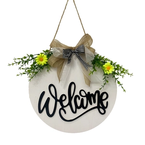 Round wooden welcome sign with yellow daisies, green leaves and a plaid burlap bow