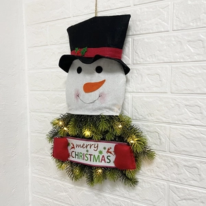 Detail of a light-up snowman Christmas wreath with LED lights and Merry Christmas banner