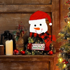 Christmas snowman topper with red plaid scarf and merry Christmas banner on a fireplace