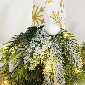 Detail of Christmas gnome with warm LED lights, faux snow tips and gold snowflake hat
