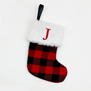 Detail of red and black buffalo plaid Christmas stocking with white faux fur and letter J