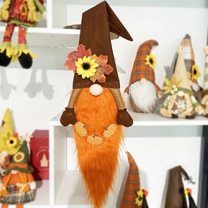 Detail of harvest gnome doll with orange beard, maple leaves and pumpkin accessories