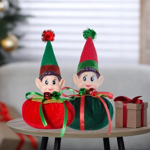 Detail of red and green Christmas elf dolls with sequins and bells on a wooden table