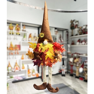 Détail d'un gnome décoratif suspendu avec corps en feuilles d'érable et guirlande LED